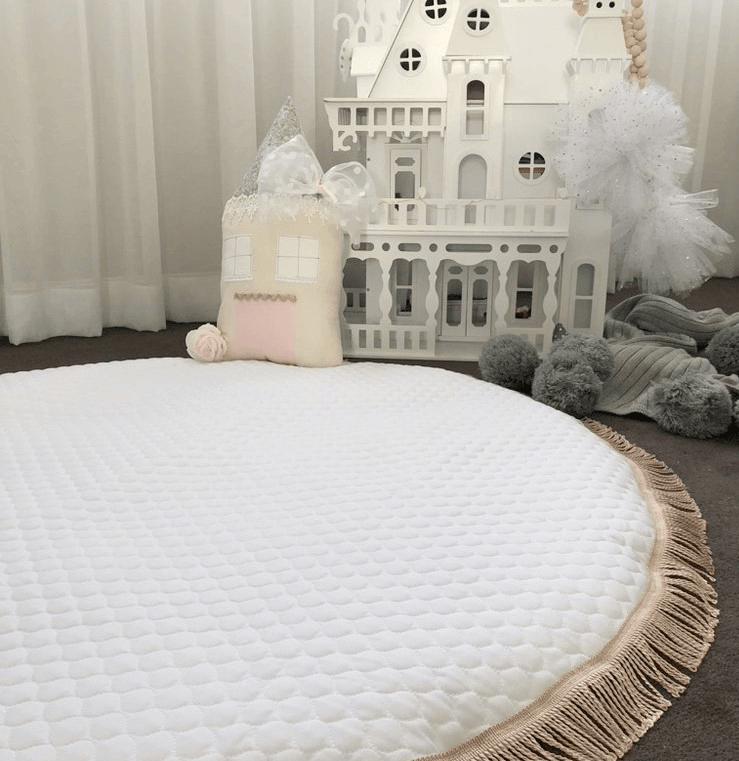 White Quilted Baby Playmat On Floor In Nursery